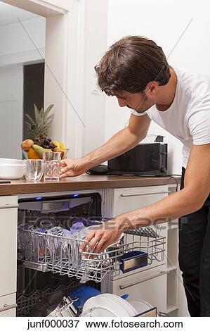 Sourire Jeune Homme Vider Les Lave Vaisselle Banque De Photo Junf000037 Fotosearch