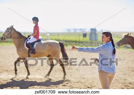 Coach and girl on horse on riding ring Stock Photo ...