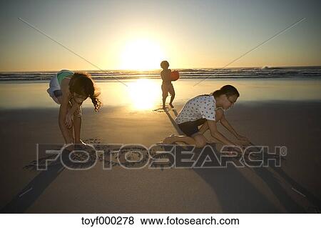 Enfants Plage A Coucher Soleil Dessin Dans Sable Banque De Photo Toyf Fotosearch