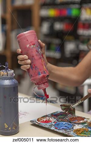 Download Girl's hand pressing paint bottle in an art class Stock Image | zef005011 | Fotosearch