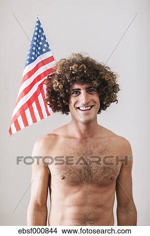 Portrait Of Naked Man With Curly Hair In Front Of American Flag