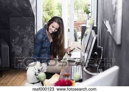 Smiling Young Woman With Dog At Desk Stock Image Reaf000123