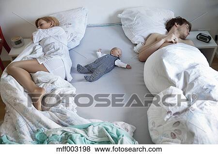 baby sleeping in bed with parents