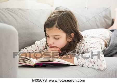 Girl Lying On The Couch Reading A Book Stock Photo Lvf05678