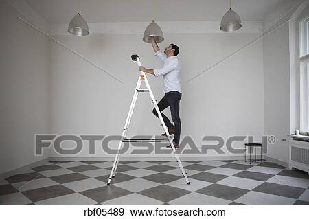 Mann Stehen Auf Leiter In Ein Leeres Zimmer Andern Zwiebel Von Hochstmass Licht Stock Foto Rbf054 Fotosearch