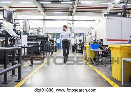 Man With Tablet Walking In Factory Shop Floor Stock Photo