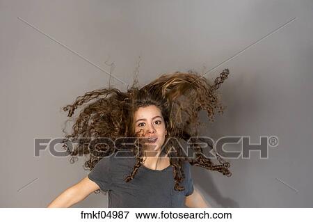 Pretty Teenage Girl With Curly Hair Jumping Stock Photo