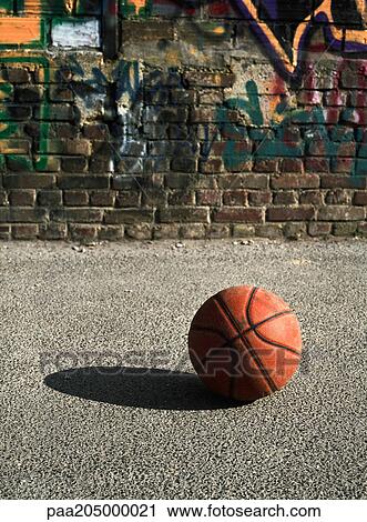 Basketball on ground next to graffitied wall View Large Photo Image Stock Image - Basketball on ground next to graffitied wall. Fotosearch