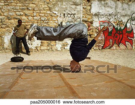 Man balancing on head, break dancing, man in background watching View Large Photo Image Stock Photograph - Man balancing on head, break dancing, man in background watching. Fotosearch