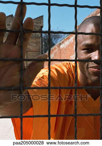 Man behind fence, close-up View Large Photo Image Stock Photo - Man behind fence, close-up. Fotosearch