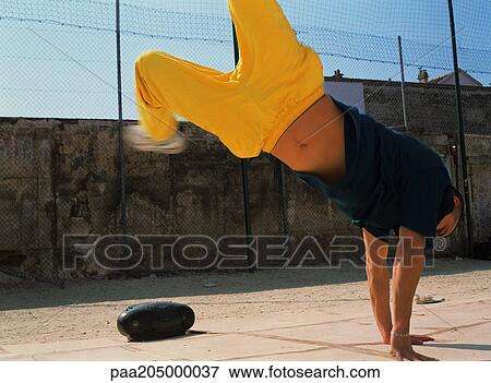 Man break dancing on hands next to radio in urban setting View Large Photo Image Stock Photo - Man break dancing on hands next to radio in urban setting. Fotosearch