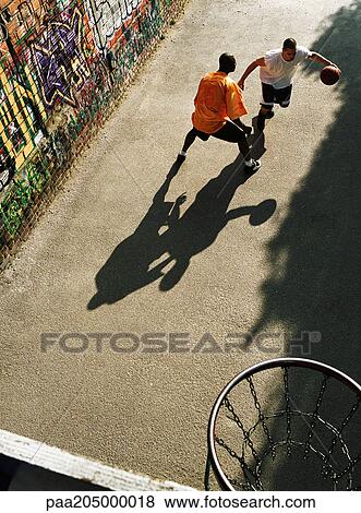 Man dribbling basketball, opponent blocking in urban playground View Large Photo Image Stock Photo - Man dribbling basketball, opponent blocking in urban playground. Fotosearch