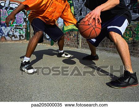 Man dribbling basketball, opponent blocking, next to graffitied wall, close-up View Large Photo Image Stock Photography - Man dribbling basketball, opponent blocking, next to graffitied wall, close-up. Fotosearch