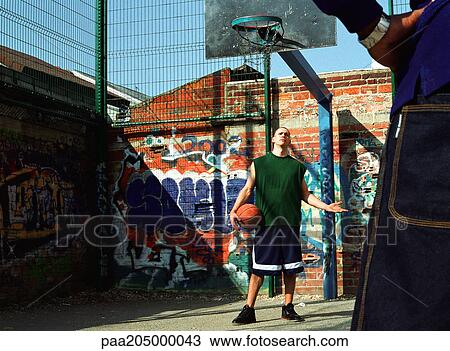 Man holding basketball, arm out, looking at second man View Large Photo Image Stock Image - Man holding basketball, arm out, looking at second man. Fotosearch