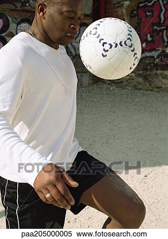 Man juggling soccer ball in front of graffitied wall View Large Photo Image Stock Photography - Man juggling soccer ball in front of graffitied wall. Fotosearch