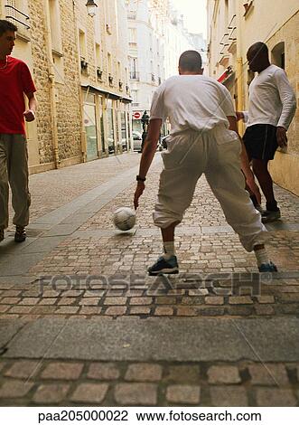 Men playing soccer in street View Large Photo Image Stock Image - Men playing soccer in street. Fotosearch