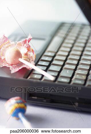 Stock Photograph - Laptop with lollipops, close-up. Fotosearch