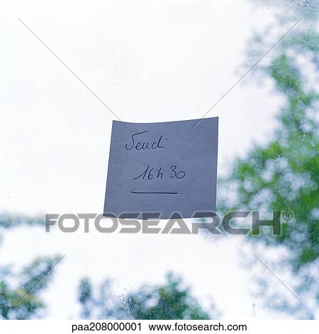 Stock Image - Adhesive note on pane of glass, close-up. Fotosearch