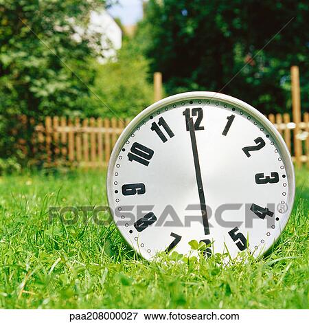 Clock on the grass. View Large Photo Image Stock Photo - Clock on the grass.. Fotosearch