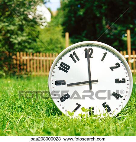 Clock on the grass. View Large Photo Image Stock Photo - Clock on the grass.. Fotosearch