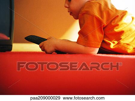 Child on floor with remote control, side view. View Large Photo Image Stock Photo - Child on floor with remote control, side view. . Fotosearch