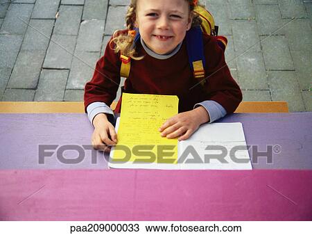 Little girl holding paper, looking up at camera View Large Photo Image Stock Image - Little girl holding paper, looking up at camera. Fotosearch
