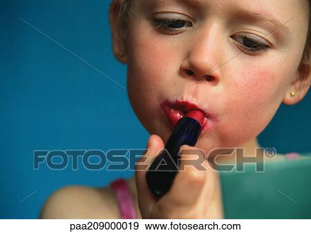 Little girl putting on lipstick, close-up. View Large Photo Image Stock Photo - Little girl putting on lipstick, close-up. . Fotosearch