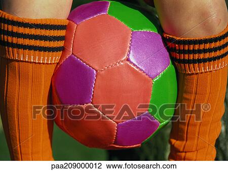 Stock Image - Soccerball between legs, close up.. Fotosearch