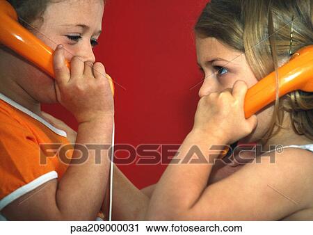 Stock Image - Two children with telephones, close-up. . Fotosearch