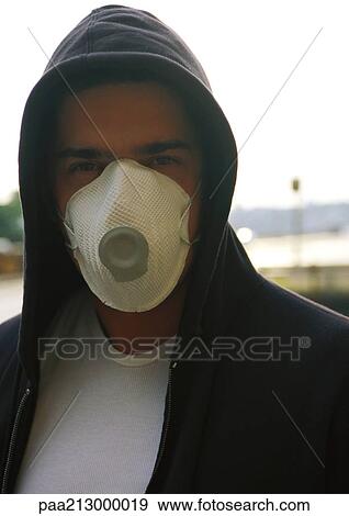 Man wearing hooded sweatshirt and white dust mask over nose and mouth View Large Photo Image Stock Photo - Man wearing hooded sweatshirt and white dust mask over nose and mouth. Fotosearch
