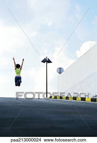 Person jumping in middle of road View Large Photo Image Picture - Person jumping in middle of road. Fotosearch