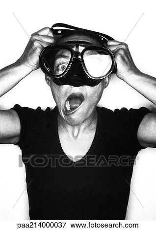 Stock Photo - Woman putting on diving goggles, portrait, b&w.. Fotosearch