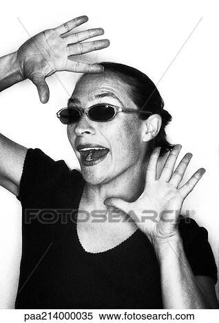Stock Photography - Woman wearing sun glasses, hands framing face, portrait, b&w.. Fotosearch