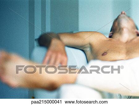 Shirtless man sitting in armchair with head back, focus on man's chest in background View Large Photo Image Stock Image - Shirtless man sitting in armchair with head back, focus on man's chest in background. Fotosearch