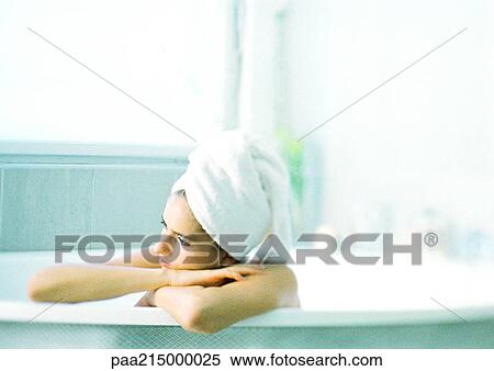 Woman in bathtub leaning on edge of tub, hair wrapped in towel View Large Photo Image Stock Photography - Woman in bathtub leaning on edge of tub, hair wrapped in towel. Fotosearch