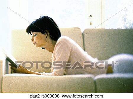 Woman lying on sofa, reading. View Large Photo Image Stock Photo - Woman lying on sofa, reading.. Fotosearch