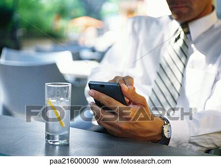 Businesman using electronic organizer in restaurant View Large Photo Image Stock Image - Businesman using electronic organizer in restaurant. Fotosearch