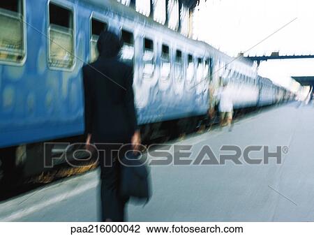 Businesswoman on platform next to train, rear view, blurred. View Large Photo Image Stock Image - Businesswoman on platform next to train, rear view, blurred.. Fotosearch