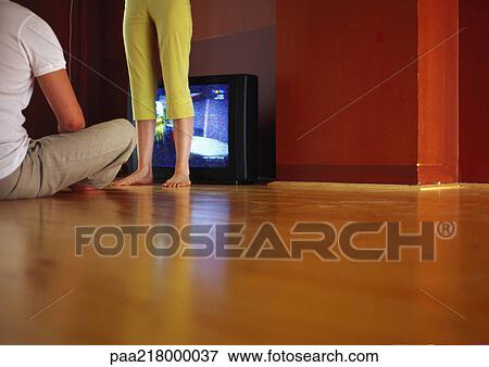 Couple in front of television on floor, surface level view View Large Photo Image Stock Photo - Couple in front of television on floor, surface level view. Fotosearch