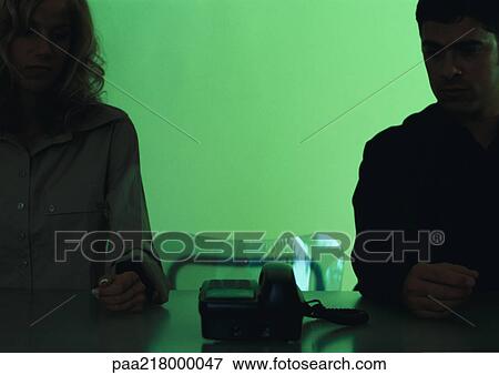 Couple sitting at a table with telephone. View Large Photo Image Stock Photo - Couple sitting at a table with telephone.. Fotosearch