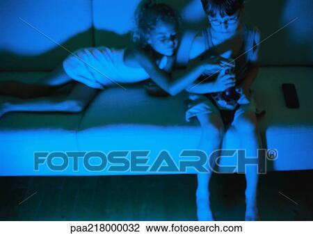 Little boy and girl on sofa in dark View Large Photo Image Stock Image - Little boy and girl on sofa in dark. Fotosearch