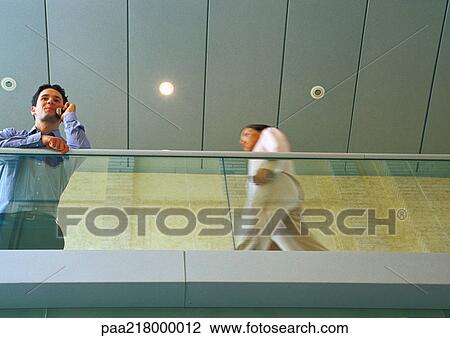 Man using cell phone, on walkway, low angle. View Large Photo Image Stock Image - Man using cell phone, on walkway, low angle.. Fotosearch