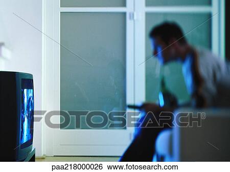 Man watching television, side view, blurred. View Large Photo Image Stock Photograph - Man watching television, side view, blurred.. Fotosearch