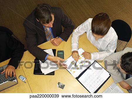 Businessmen and woman, looking at ledger, elevated view. View Large Photo Image Stock Photo - Businessmen and woman, looking at ledger, elevated view.. Fotosearch