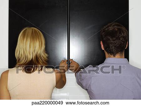 Couple with hands on cupboard doors, rear view. View Large Photo Image Stock Photo - Couple with hands on cupboard doors, rear view.. Fotosearch