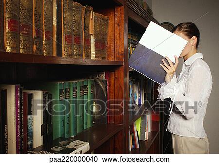 Young woman taking book from bookshelf. View Large Photo Image Stock Image - Young woman taking book from bookshelf.. Fotosearch