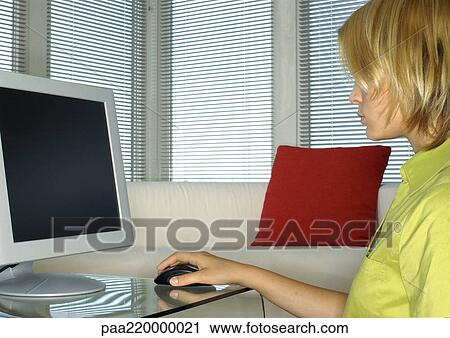 Young woman using computer, side view. View Large Photo Image Stock Image - Young woman using computer, side view.. Fotosearch