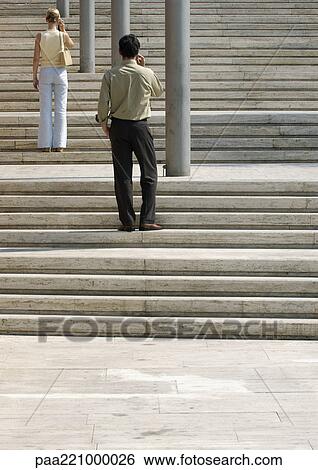 Man and woman standing on stairs outside, rear view View Large Photo Image Stock Photograph - Man and woman standing on stairs outside, rear view. Fotosearch
