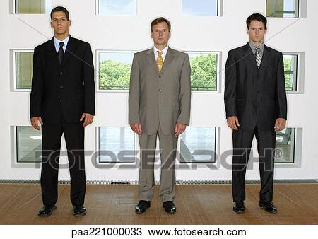 Three businessmen standing in a line View Large Photo Image Stock Image - Three businessmen standing in a line. Fotosearch