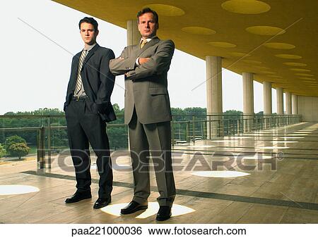 Two businessmen looking into camera View Large Photo Image Stock Photograph - Two businessmen looking into camera. Fotosearch